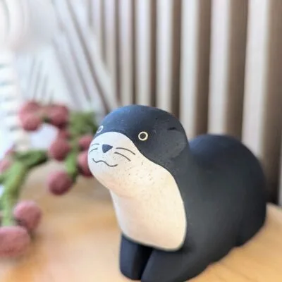 Figurine loutre noire en bois Pole Pole de la marque T-Lab, fabriquée à la main.