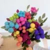 Fleur boule en laine 2 cm : gros bouquet de fleurs boules en feutre de laine et feuillages tenu dans une main.