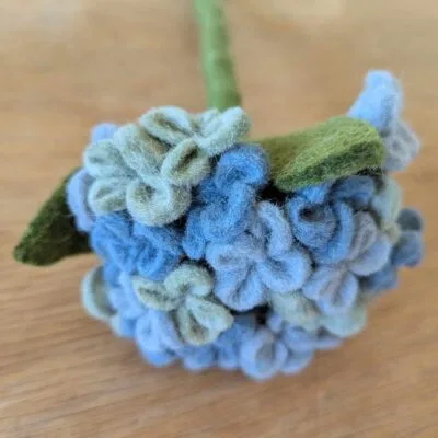 Grand hydrangea bleu en feutre Gry & Sif vue seule sur une surface en bois