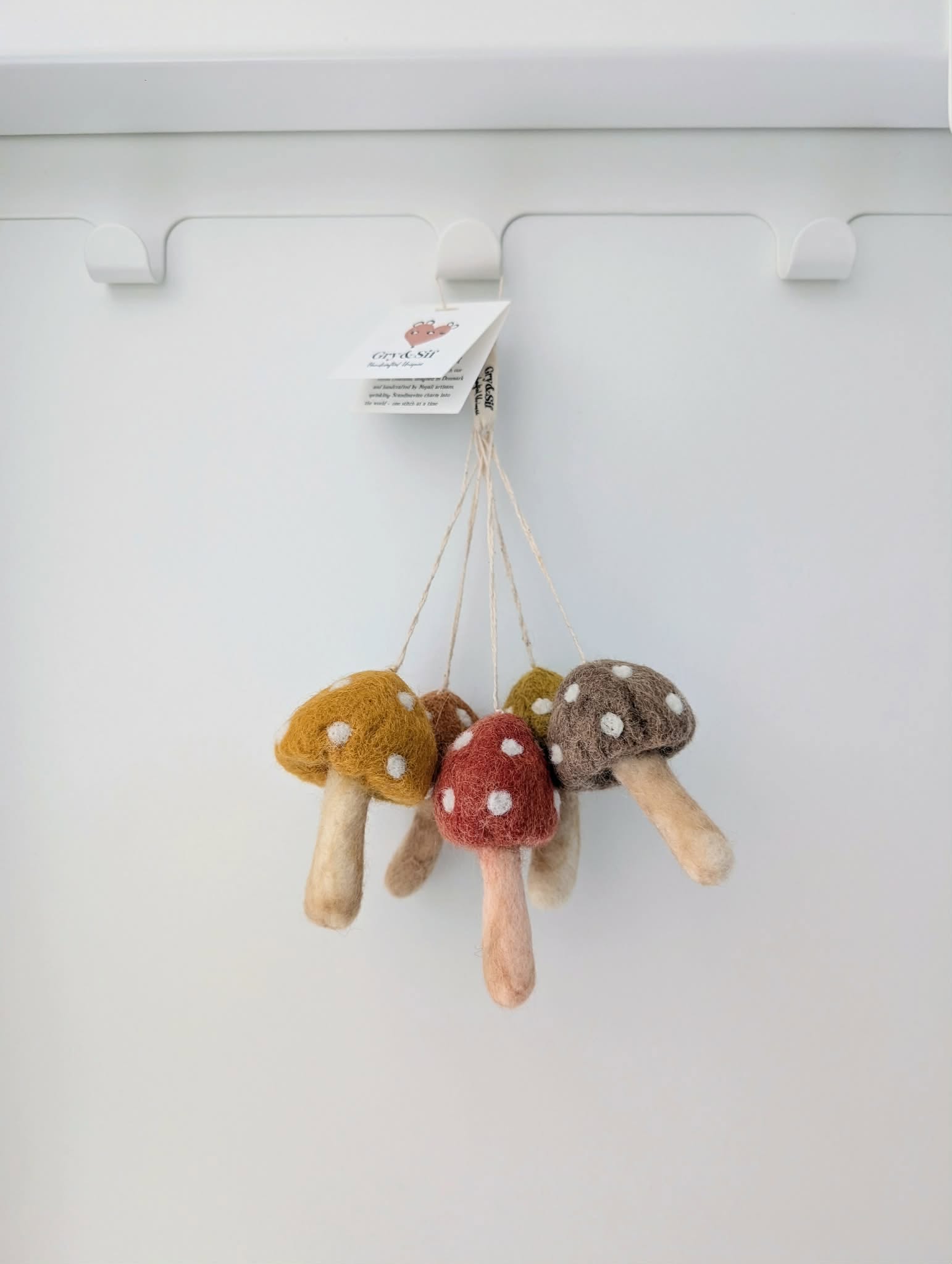 Bouquet de 5 champignons en feutre Gry & Sif suspendu à un crochet avec son étiquette
