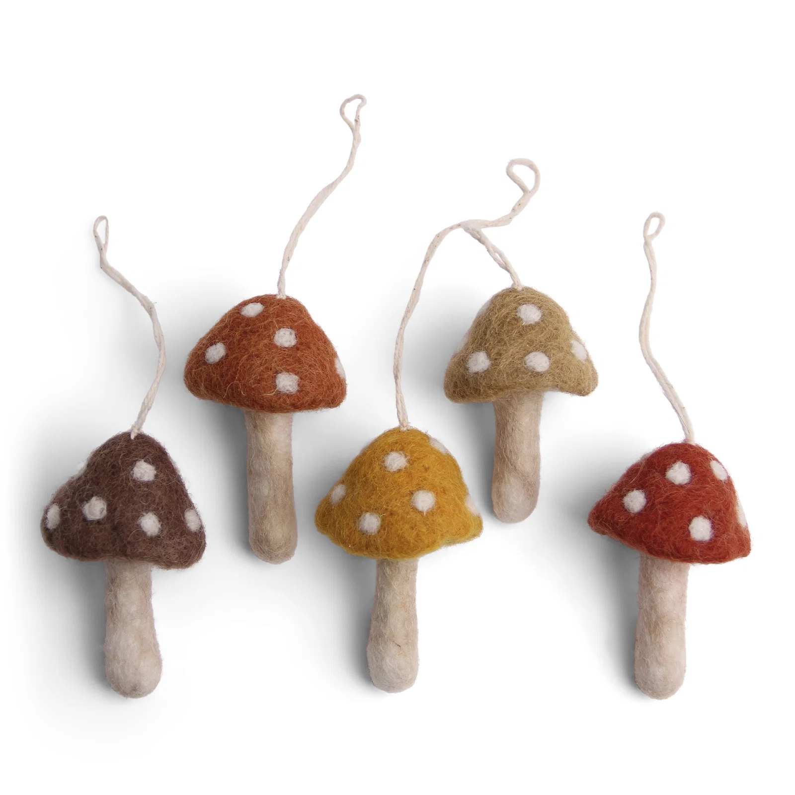 Cinq champignons en feutre Gry & Sif aux chapeaux mouchetés de blanc, dans des tons brun, rouille, moutarde et olive, sur fond blanc